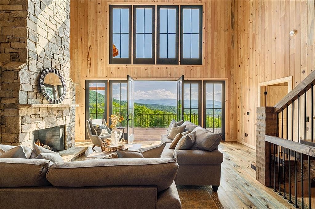 Great room with stone fireplace and floor-to-ceiling windows